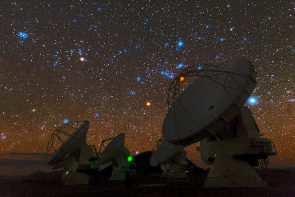 Star‑filled night sky over the ALMA observatory with ancient constellations visible, illustrating themes connected to the Pleiadian Lineup.