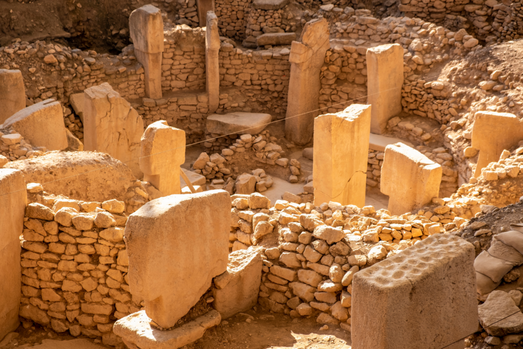 T‑shaped stone pillars arranged in a circular enclosure at Göbekli Tepe under soft, directional light.
