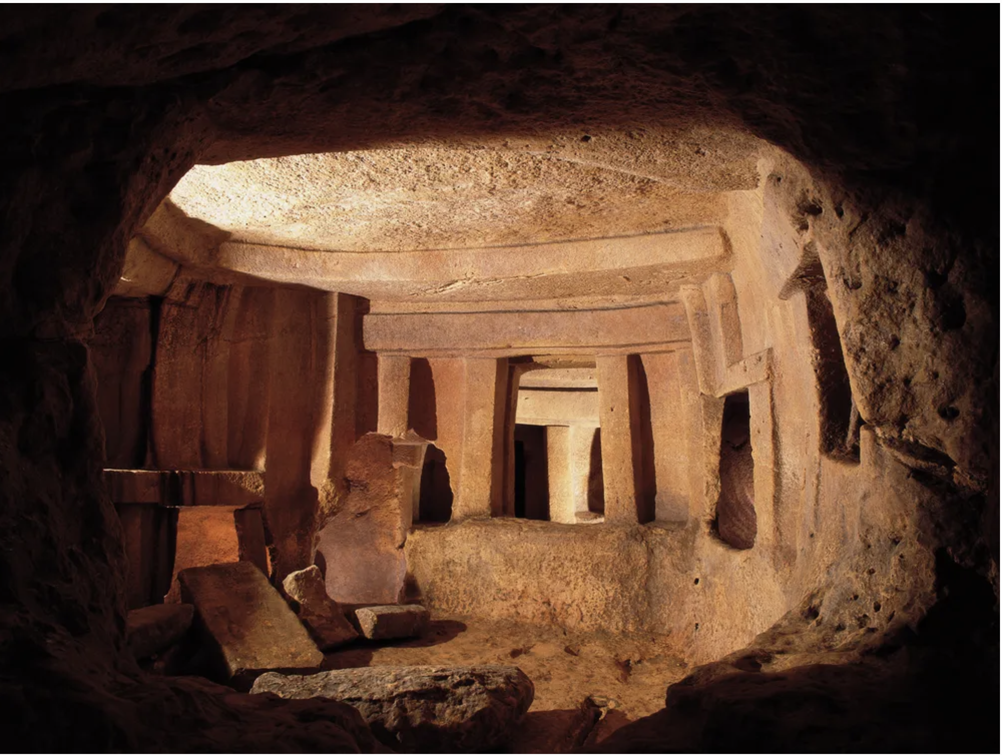 A view inside the Ħal Saflieni Hypogeum showing carved limestone chambers, pillars, and passageways with rough, ancient stone textures.