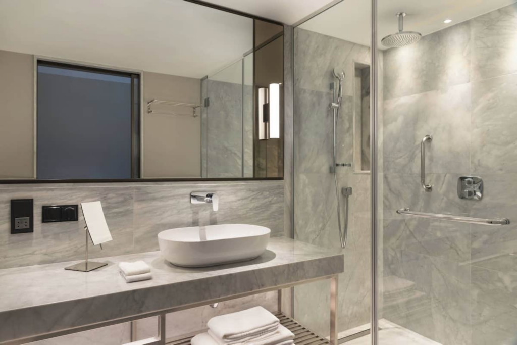 Marriott bathroom featured on the Starseed Türkiye Adventure with Althea Provost, showing marble finishes and a glass shower.