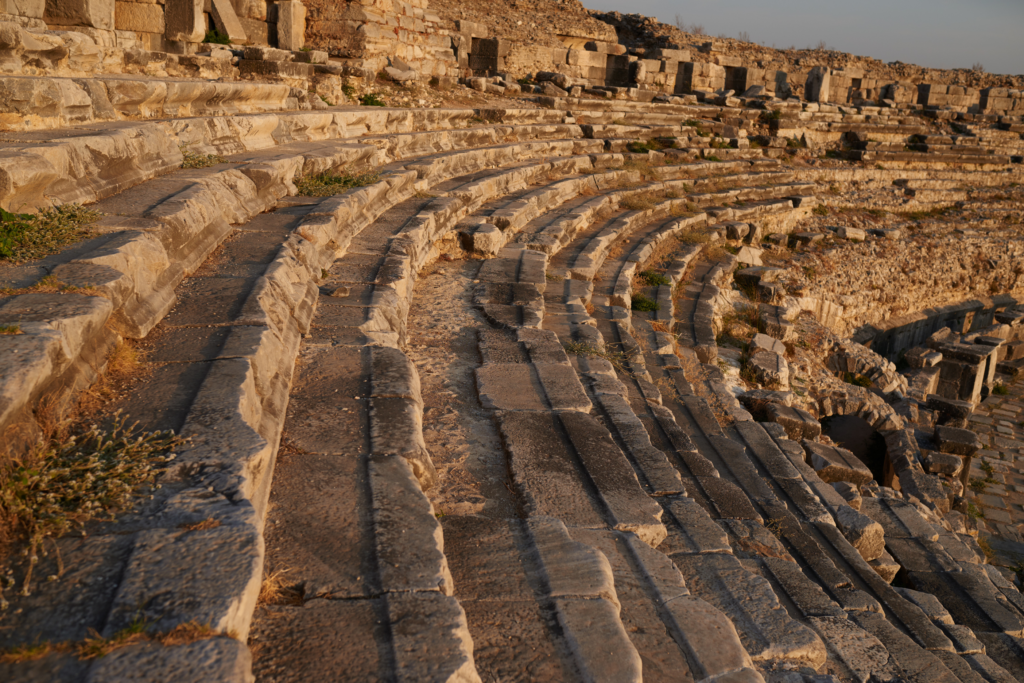 Ancient amphitheater at Miletus explored during the Starseed Türkiye Adventure with Althea Provost, featuring curved stone seating in warm Aegean light.