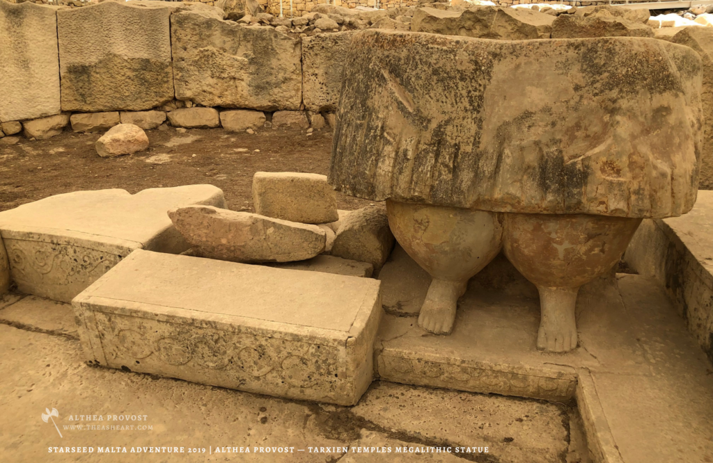 Starseed Malta Adventure 2019 | Althea Provost — lower‑body statue from the Tarxien Temples showing carved skirt folds and monumental legs within the excavated megalithic site.