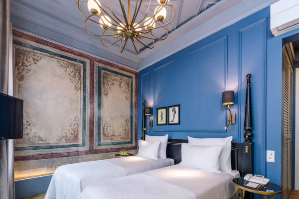 Twin room with blue accent wall at The Soul Hotel on the Starseed Türkiye Adventure with Althea Provost, blending classical and modern design.