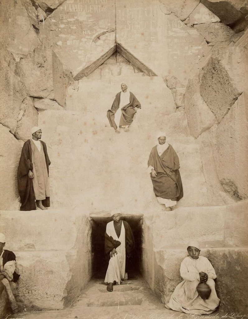 Chevron-shaped structure above the Great Pyramid entrance with six figures posed around the doorway in Zangaki photograph No. 752