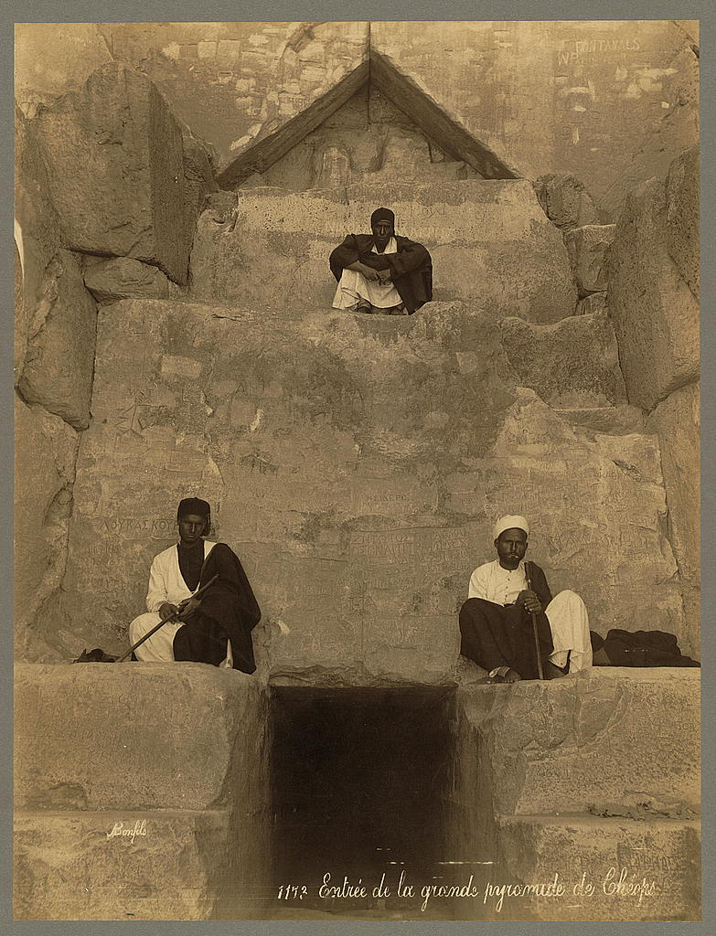 Chevron-shaped structure above the Great Pyramid entrance with three men seated on limestone blocks in Bonfils photograph no. 1173, 1867-1899.