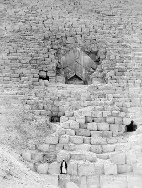 Chevron-shaped structure above the Great Pyramid entrance with a man standing below the doorway in Lekegian photograph No. 14, c. 1885