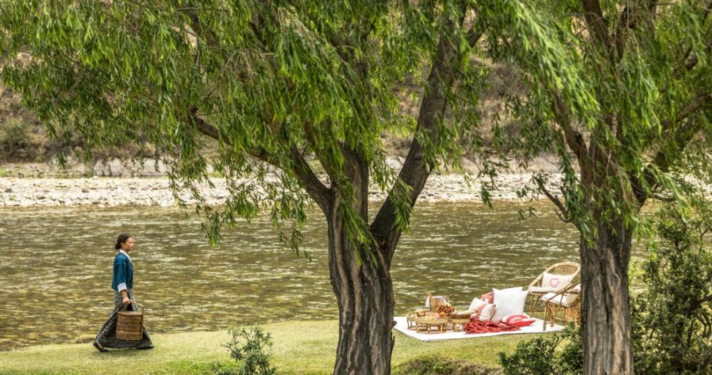 Starseed Bhutan Adventure with Althea Provost picnic setup on a grassy knoll beside water in Bhutan.