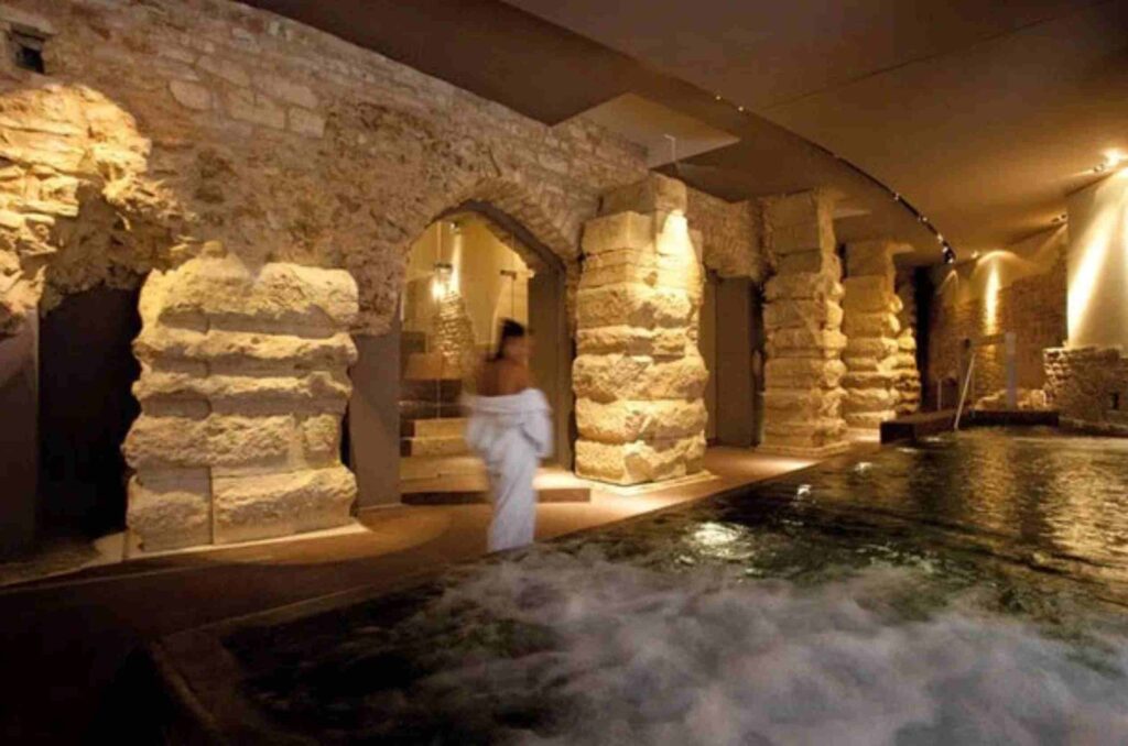 Saint Francis Walking Tour with Althea Provost visiting the underground Roman spa with limestone pillars at Nun Assisi Relais and Spa Museum in Assisi Italy