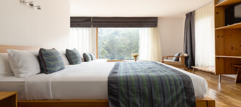 Starseed Bhutan Adventure with Althea Provost — double occupancy room at Zhiwaling Ascent with forest‑view windows and modern Bhutanese design.